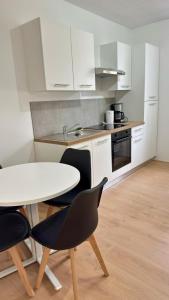 Cosy 5 - Belfort centre في بلفور: مطبخ مع طاولة وكرسيين وطاولة +11 صورة