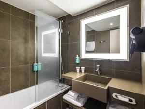 a bathroom with a sink and a shower at Novotel Strasbourg Centre Halles in Strasbourg
