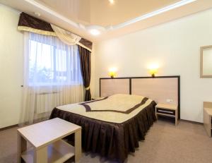 una camera d'albergo con letto e finestra di Hotel Kovcheg a Surgut
