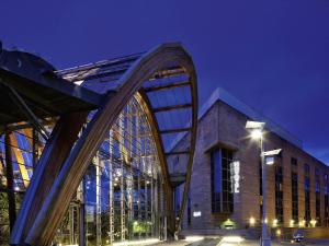 a large building with a large glass facade at night at Novotel Sheffield Centre in Sheffield