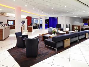 a lobby with couches and chairs in a building at Novotel Sheffield Centre in Sheffield