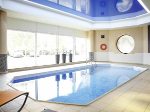a large swimming pool with a blue ceiling at Novotel Sheffield Centre in Sheffield