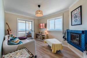 a living room with a couch and a fireplace at Charming Beachside Escape in Esmoriz