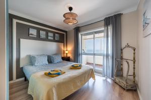 a bedroom with a bed and a large window at Charming Beachside Escape in Esmoriz
