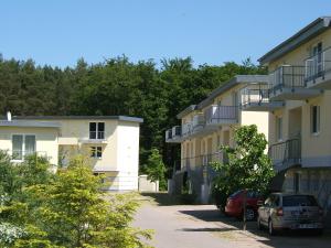 Ferienwohnung Küstenwaldblick mit privat Sauna, 87qm & 2 Schlafzimmern في غرال موريتز: صف من المباني مع السيارات تقف في موقف للسيارات