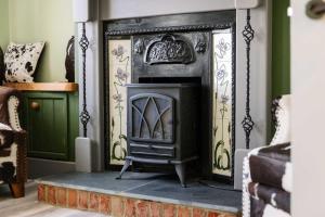 a fireplace in a living room with a stove at Charming Jersey Cottage with parking 8 Guests in Cowes