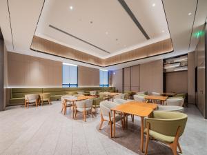 ein Esszimmer mit Tischen und Stühlen in der Unterkunft JI Hotel Chengdu Sichuan Normal University in Chengdu