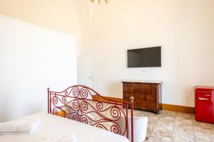 a bedroom with a bed and a tv on the wall at Palazzo Celina in Gallipoli