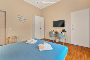 Fiordarancio Room Rental في مونتيروسّو ال ماري: غرفة نوم مع منشفتين على سرير أزرق