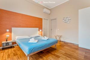 Fiordarancio Room Rental في مونتيروسّو ال ماري: غرفة نوم بها سرير عليه منشفتان