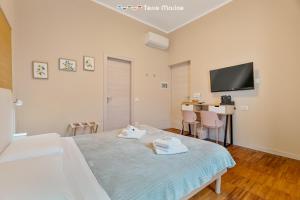 Fiordarancio Room Rental في مونتيروسّو ال ماري: غرفة نوم بها سرير وتلفزيون على الحائط