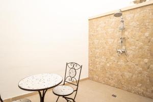 a table and two chairs next to a stone wall at Palazzo Celina in Gallipoli