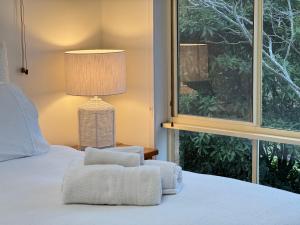 a bedroom with a bed with a chair and a window at Palacete Beach Resort - entire home in Culburra Beach