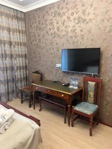 Una habitación con un escritorio y un televisor en la pared. en Historical Old City Hotel, en Baku