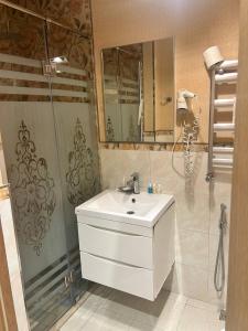 Un baño con lavabo blanco y ducha en Historical Old City Hotel, en Baku