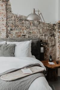 فندق ماذر غوز في أوتريخت: غرفة نوم بها سرير ومصباح على طاولة