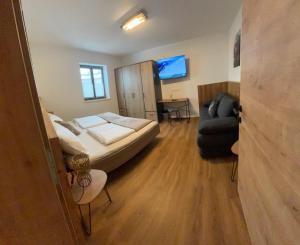 Appartement Steinbergrose في ليوغانغ: غرفة نوم بسرير وكرسي وأريكة