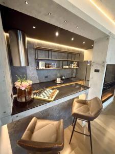 a kitchen with a counter and two chairs at smgold lux apartman in Podgorica