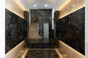 a staircase in a lobby with black marble at Boutique Hotel Travé Rome City Centre in Rome +15 photos