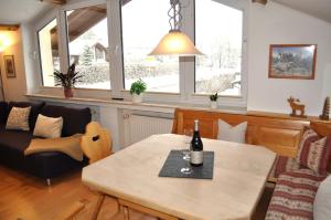 a living room with a table with a bottle of wine on it at Mayers Urlaubsnest in Bad Hindelang