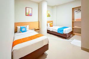 a hotel room with two beds in a room at Sans Stay Wonder Karapitan in Bandung +39 photos