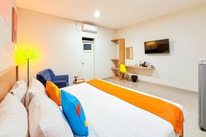 a bedroom with a large bed and a tv at Sans Stay Wonder Karapitan in Bandung