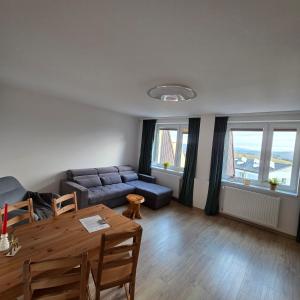 Słoneczny Apartament Panorama 5 7 z Widokiem na Jezioro i Góry في بولانكسيك: غرفة معيشة بها أريكة وطاولة