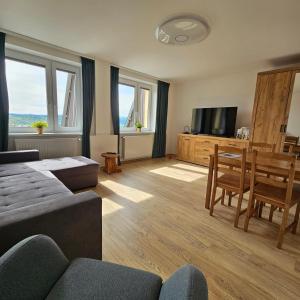 Słoneczny Apartament Panorama 5 7 z Widokiem na Jezioro i Góry في بولانكسيك: غرفة معيشة مع أريكة وغرفة طعام