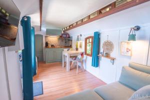 a living room and kitchen in a tiny house at Roulotte avec bain nordique privatif chauffé, Séjour calme et bien-être in Fichous-Riumayou