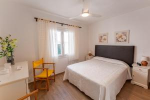a bedroom with a bed and a desk and a chair at Casa Abril by Escape Home in S'Algar
