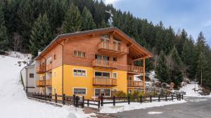 a large wooden building in the snow with trees at Zardin 7 in Valdidentro