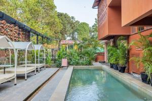 a swimming pool in the middle of a house at Unseen Boutique Hotel, Assagao in Assagao