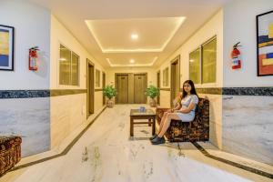 Una mujer sentada en una silla en un pasillo. en Via CT Palace, en Bhopal