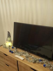 a flat screen tv sitting on top of a dresser at Appartement cosy vue port in Dives-sur-Mer