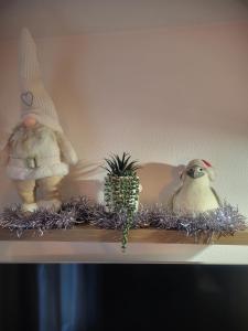 a shelf with two stuffed animals and a pineapple and a bird at Appartement cosy vue port in Dives-sur-Mer
