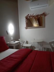 Schlafzimmer mit einem roten Bett, einem Tisch und Stühlen in der Unterkunft B&B L'incanto del Golfo in Agropoli