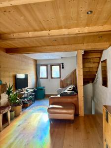 a living room with wooden ceilings and a couch at Chalet Beaufort in Saint-Martin-de-Belleville