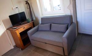 a living room with a chair and a tv at Les chambres de Marie in Villié-Morgon