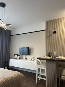 a hotel room with a bed and a table and a tv at Premium Line Apartman 3 in Sombor