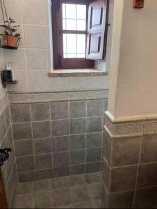 a bathroom with a tiled shower with a window at Casa Balcón in Granada +43 photos