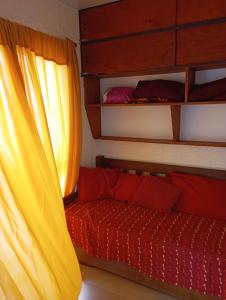 a bedroom with a bunk bed and a red couch at Brisa de Mar. in La Pedrera