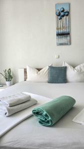 a white bed with a green pillow on it at Apartments Matanovi Dvori in Makarska +85 photos