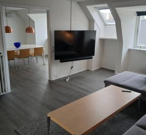 a living room with a large flat screen tv on the wall at Eksklusiv stort boende i Fredrikshavn in Frederikshavn