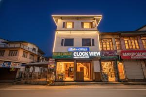 a white building with a clock tower on a street at FabHotel Clock View 500M From The Mall Road in Mussoorie