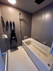 Un baño con bañera y una silla en la pared. en カタツムリ, en Shiogama 85 fotos más