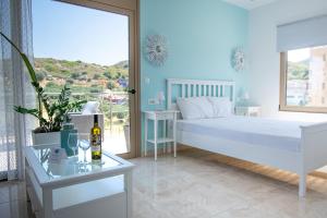 um quarto com uma cama branca e uma mesa de vidro em ''Aetheria'' Rooftop Resort Rhodes with sea view em Kremasti