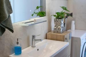 uma casa de banho com um lavatório e um vaso com uma planta em ''Aetheria'' Rooftop Resort Rhodes with sea view em Kremasti mais 45 fotografias