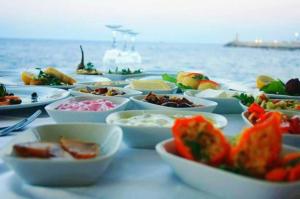 a table topped with bowls of food on the water at DOME Hotel & Casino Central Kyrenia ! in Kérynia