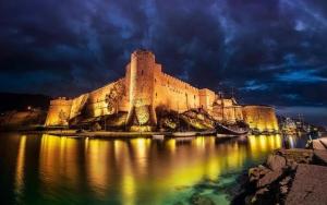a large castle sitting in the water at night at DOME Hotel & Casino Central Kyrenia ! in Kérynia