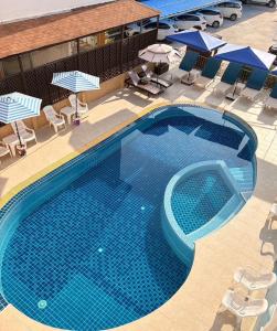 an overhead view of a swimming pool with chairs and umbrellas at Baan Chanchay Hua Hin in Hua Hin